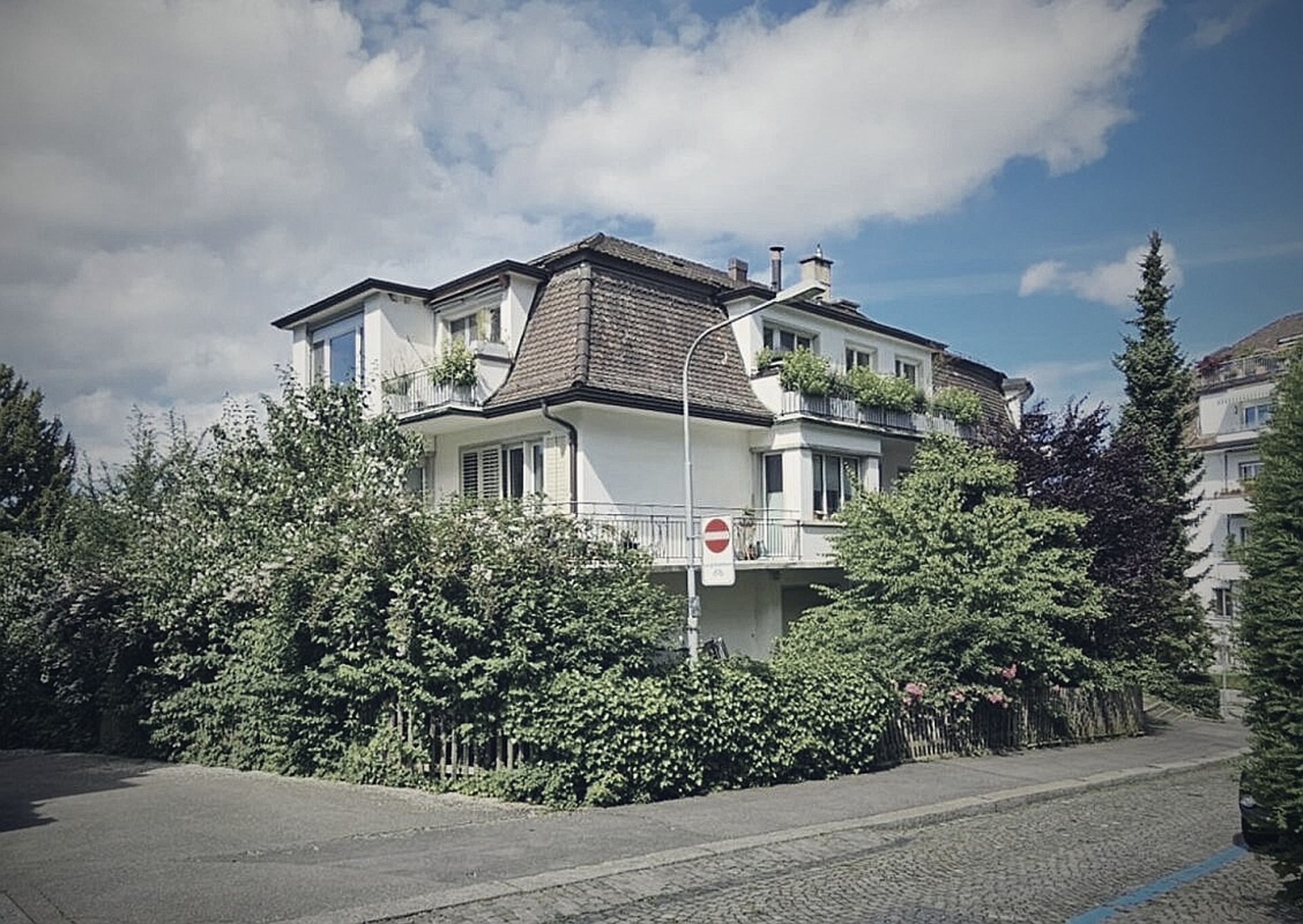 Wohnhaus in Zürich, Aussenansicht mit Hecke und Vorplatz